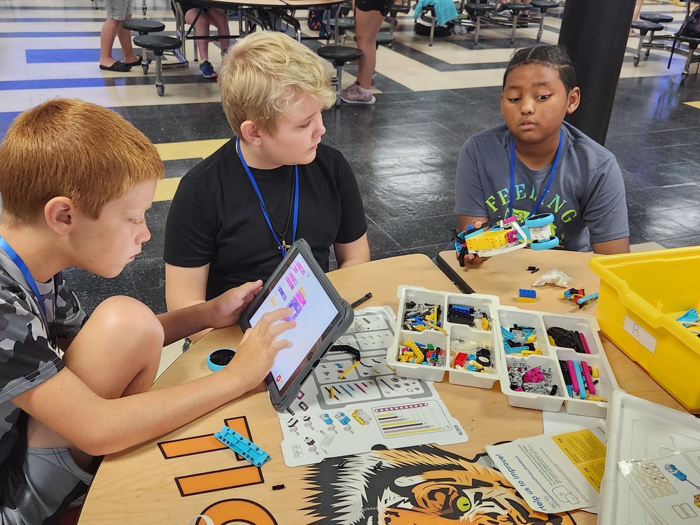 Campers use a computer to program their robot.